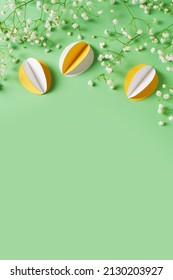 Yellow Paper Crafting Eggs On Green Background, Easter And Spring Concept, Top View, Copy Space, Vertical