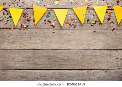 Yellow Paper Flags Garland On Rustic Wood. Birthday Party Decoration Background, Top View, Copy Space. Mockup For Greeting Card