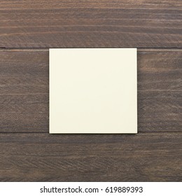 Yellow paper note on brown wooden background. - Shutterstock ID 619889393