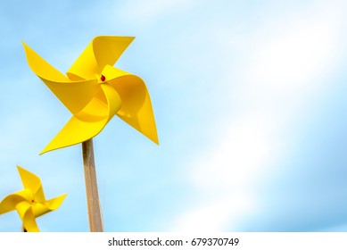 Yellow Paper Windmills, With Blue Sky Background.