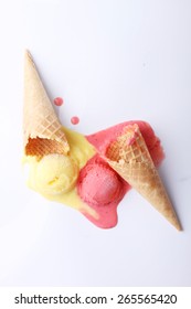 yellow passion fruit and red strawberry ice cream cones dropped melt on ground