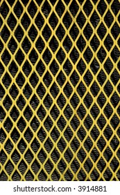 A yellow patterned wire grid. The image is shot in portrait