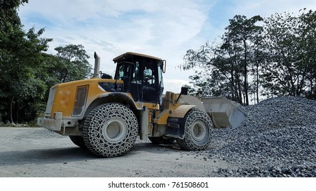 yellow pay loader is loading limestone at the yard