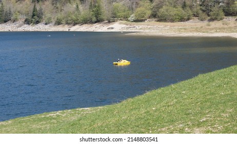 Yellow pedalboat in the mountain lake