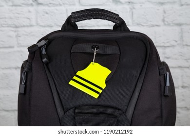 Yellow Pedestrian Safety Reflector On A Black Backpack. Concept Of Safety  On The Road