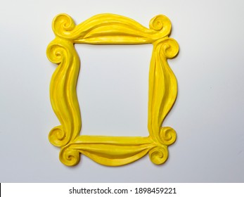 Yellow photo frame or mirror frame with a white background, to frame texts or images.