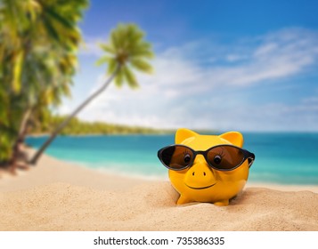 Yellow piggy bank with sunglasses with a tropical beach in the background