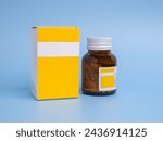 Yellow pill bottle and yellow pill box on blue background with copy space. Space for text. Medical and health care concepts.