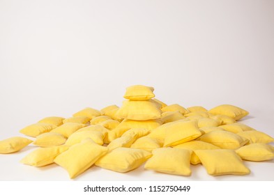 Yellow pillows stacked in a pile on a light background