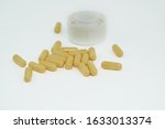 Yellow pills an pill bottle on white background.