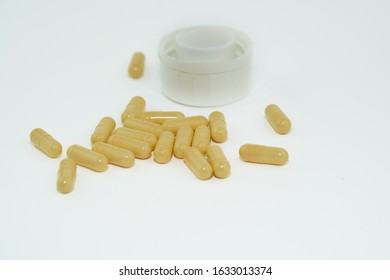 Yellow pills an pill bottle on white background.