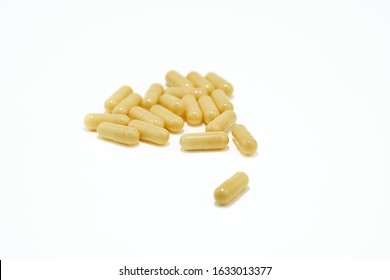 Yellow pills an pill bottle on white background.