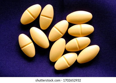 Yellow Pills Spread On Dark Blue Table Cloth 