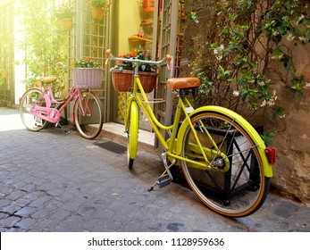 Yellow and pink color bicycles parked on the old street in Rome, Italy