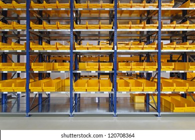Yellow plastic bin trays at shelf in warehouse