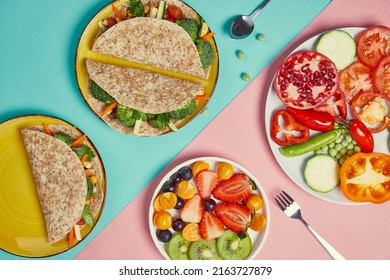 Yellow plate with wholemeal tortillas stuffed with broccoli, tomato, cucumber, carrot, sweet corn, nuts.
plate with vegetables and fruits on pink and blue background. Horizontal