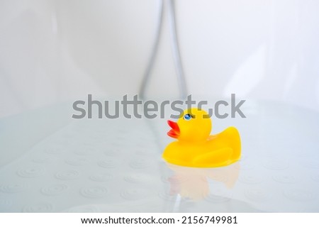 Yellow playful rubber duck float in the bathtub. Kids bath time concept. Funny toy for kits