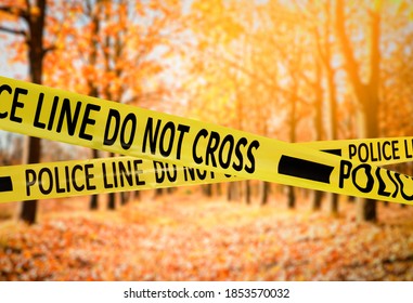 Yellow Police Tape Isolating Crime Scene. Blurred View Of Autumn Park 