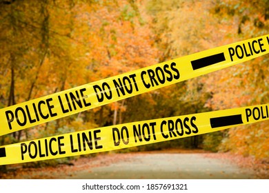 Yellow Police Tape Isolating Crime Scene. Blurred View Of Autumn Park 