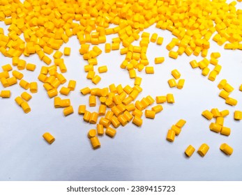 Yellow polymer masterbatch granules isolated on a white background are suitable for background designs and plastic company profile photo banners