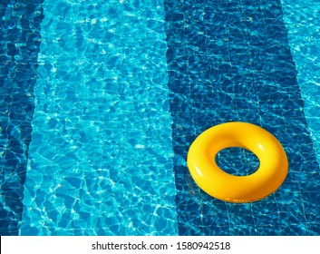 Yellow pool float, ring floating in a refreshing blue swimming pool