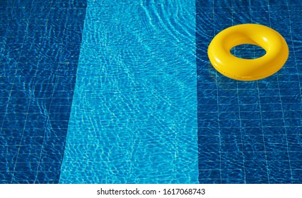 Yellow pool float, ring floating in a refreshing blue swimming pool