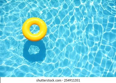 Yellow pool float, ring floating in a refreshing blue swimming pool - Shutterstock ID 254911351