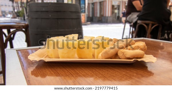 Yellow Portuguese\
sheep\'s cheese, cut into pieces and served in a bar outside.\
Portuguese food concept.