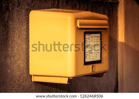 Yellow postbox at the wall