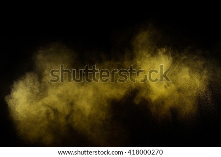Yellow powder explosion on black background. Colored powder cloud. Colorful dust explode. Paint  Holi.