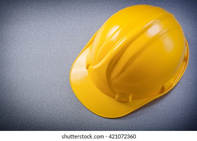 Yellow Protective Hard Hat On Grey Background Directly Above Construction Concept.