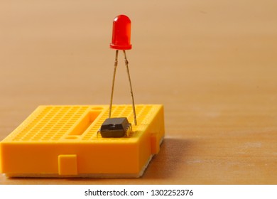 Yellow protoboard with an IC and LED
