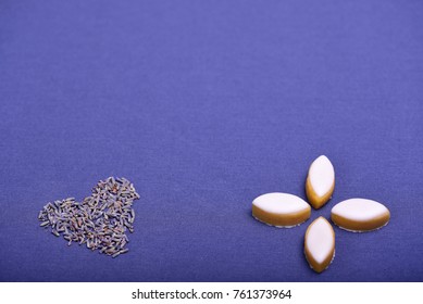 Yellow Provence calissons sweets and lavender heart on blue background.