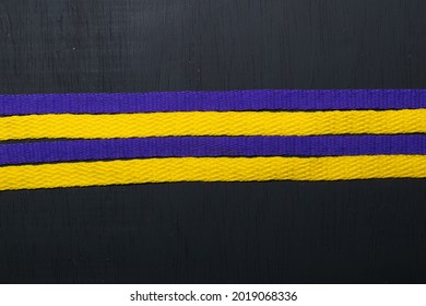 Yellow And Purple Shoelaces, Lakers Flag, On Black Wooden Background, Leaving Space For Advertising Text