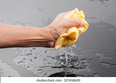 yellow PVA chamois for car cleaning in man's hand