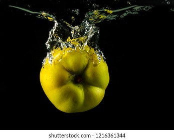 Yellow Quince Spash In Water On Black Background