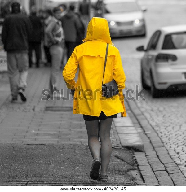 Yellow rain coat in\
black and white street
