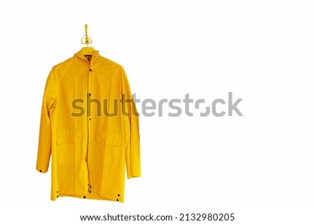 A yellow raincoat hangs on a hanger. Isolate on white background