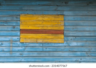 Yellow rectangle on blue surface: yellow shutter on blue wall in an traditional house facade (Talca, Chile)