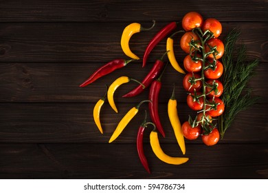 Yellow and red chili peppers on a wooden dark background. Free inscription
