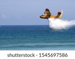 Yellow and red firefighting plane unloading water