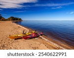 Yellow and red kayaks pulled up on the sandy beach on the shore of Great Slave Lake near Hay River in Canada