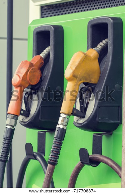 yellow and red\
petrol gas pump nozzles in a service station background green,Fuel\
nozzle in oil station\
Thailand