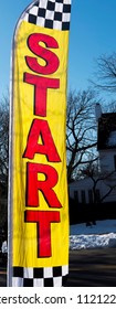 A Yellow And Red Start Sign Is Blowing In The Wind At The Start Of A 5K Road Race.