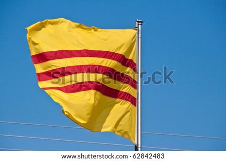 Yellow and Red Vietnamese flag blowing against a blue sky