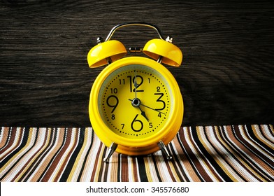 Yellow Retro Alarm Clock On Color Mat Shows 5 Oclock Horizontal