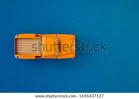 Yellow Retro car pickup on a blue-purple background. Top view with copy space. Flat lay