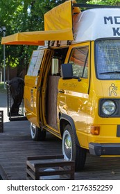 Yellow Retro Mini Bus Car Van Parked In Park, Abeled Mobile Coffee,sidewalk Cafe, Tomsk Russia May 26, 2022. Fun Vehicle, Roadtrip On Yellow Van Transport. Travel Lifestyle Concept