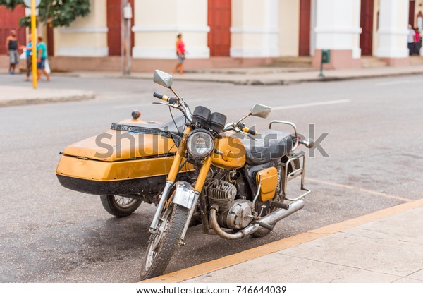 Yellow retro motorcycle on city street, Cuba,\
Havana. Copy space for\
text