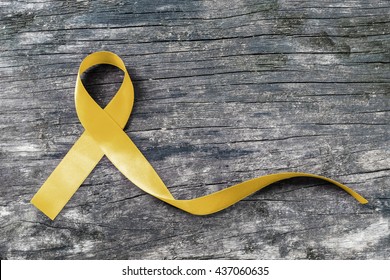 Yellow ribbon symbolic color for Sarcoma Bone cancer awareness and suicide prevention on aged wood (isolated with clipping path)